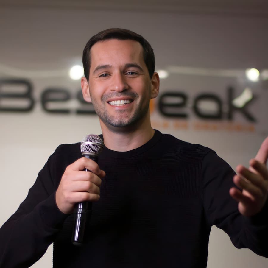 Aluno sorri e gesticula com o microfone na mão